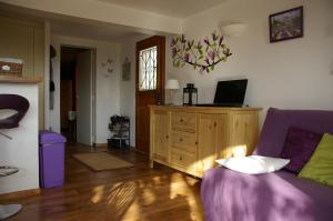 - un salon avec un canapé violet et une fenêtre dans l'établissement IA ORANA, à Gargas