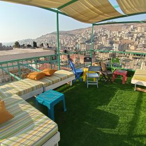 uma varanda com bancos e cadeiras e vista para a cidade em Turquoise em Nablus