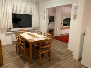 uma sala de jantar com uma mesa e cadeiras e uma televisão em Ferienwohnung Julia em Vlotho