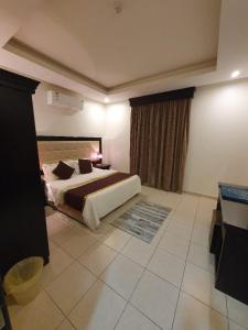 a bedroom with a large bed and a window at Katara Hotel Apartment in Riyadh