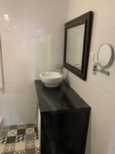 La salle de bains est pourvue d'un lavabo et d'un miroir sur un comptoir. dans l'établissement T2 - Quartier mythique du panier, à Marseille