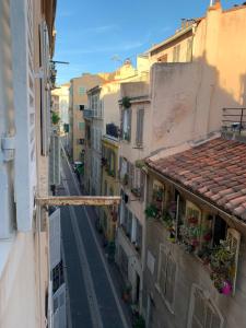 une vue sur une ruelle située entre deux bâtiments dans l'établissement T2 - Quartier mythique du panier, à Marseille