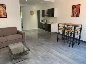 a living room with a couch and a table and a kitchen at T2 - Quartier mythique du panier in Marseille