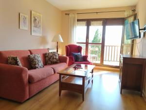 sala de estar con sofá rojo y mesa en Apartamentos Ball Benas Edificio Prados de Velarta, en Cerler
