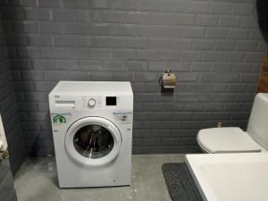 een wasmachine in een badkamer naast een toilet bij Посуточно отличная квартира в центре in Oezjhorod