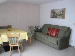 ein Wohnzimmer mit einem Sofa und einem Tisch in der Unterkunft Gästehaus Wiesenhof in Fischen im Allgäu