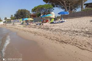 夸爾圖弗路米妮的住宿－Villino Stella di Mare，沙滩上,有遮阳伞,有人躺在沙滩上