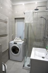 a bathroom with a washing machine and a sink at Noemiz Exclusive Apartments in Budapest