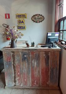 a wooden desk with a computer on top of it at Hospedaria e Hostel da Déia in Ouro Preto
