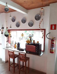 a kitchen with a counter and some plates on the wall at Hospedaria e Hostel da Déia in Ouro Preto