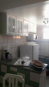 uma cozinha com armários brancos e uma bancada em Ape lindo em Porto - Oxente reserve logo em Porto Seguro