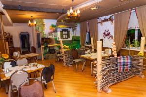 a dining room with wooden tables and chairs at Hotel General in Ekibastuz