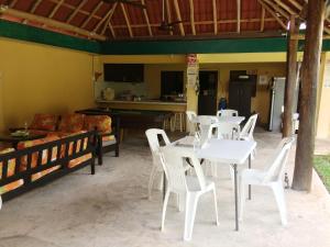a living room with white tables and white chairs at Amigos Hostel Cozumel in Cozumel