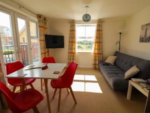 a living room with a table and red chairs at Great location nr train station & parking in Banbury in Banbury
