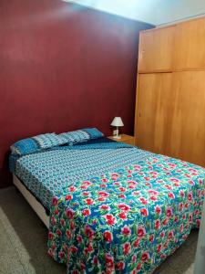 1 dormitorio con 1 cama con colcha de flores en Departamento céntrico en Santa Fe capital en Santa Fe