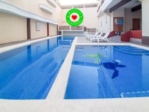 a large swimming pool with blue water in a building at Hotel Zihua Express in Zihuatanejo