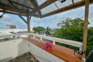 un balcón con un banco de madera y flores. en Posada J&J Forbes - 1, en San Andrés