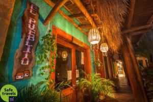 a lobby of a restaurant with plants and chandeliers at Hotel El Pueblito in Holbox Island