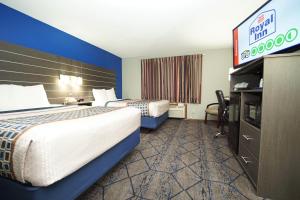 a hotel room with two beds and a tv at Royal Inn Hudson I-94 in Hudson