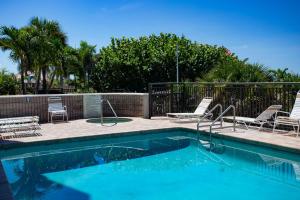 a swimming pool with lounge chairs and a swimming pool at 505 - Gulf Strand in St. Pete Beach