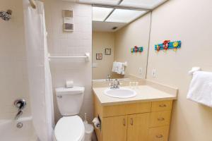 a bathroom with a toilet and a sink and a mirror at 505 - Gulf Strand in St Pete Beach