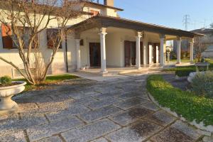 ein Haus mit einem steinernen Gehweg davor in der Unterkunft B&B Villa Adriano in Cavaion Veronese