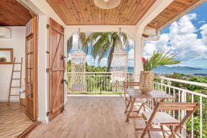 a room with a table and chairs on a balcony at Créole Bay - Suites and Spa in Fort-de-France