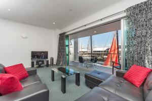 sala de estar con muebles de cuero y ventana grande en QV Private Airconditioned Waterfront Apartment - 423, en Auckland