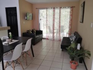 ein Wohnzimmer mit einem schwarzen Tisch und Stühlen in der Unterkunft Casa playa herradura #1 in Herradura