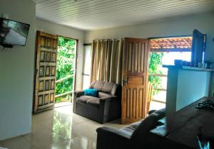 a living room with a couch and a chair and a door at Casa Tulum in Barra Grande