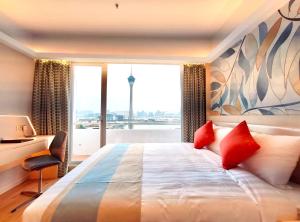 a bedroom with a large bed with a large window at Hotel Riviera Macau in Macau