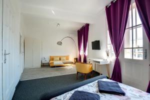 ヴァルナ・シティにあるHostel Musalaの紫色のカーテン、ベッド、デスクが備わるベッドルーム1室が備わります。