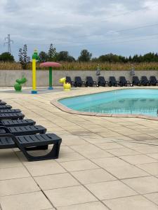 a swimming pool with lounge chairs next to a pool at Mobile home du ried à 11 KLM de Europa-Park et Rulantica in Boofzheim