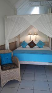 - une chambre avec un lit à baldaquin et une chaise dans l'établissement Abalone Resort, à Candidasa 47 autres photos