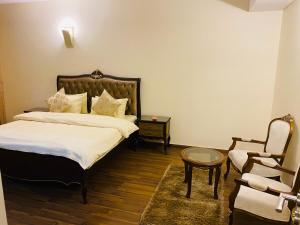 a hotel room with a bed and a chair at Royal Two Bed Luxury Apartment Gulberg in Lahore