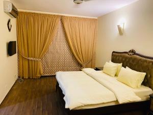 a hotel room with a bed and a window at Royal Two Bed Luxury Apartment Gulberg in Lahore