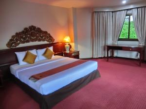 a hotel room with a large bed and a piano at Inn Come Hotel Chiang Rai in Chiang Rai +16 photos
