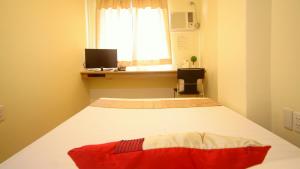 a bedroom with a large bed with a window at Anri Pension House in Cebu City