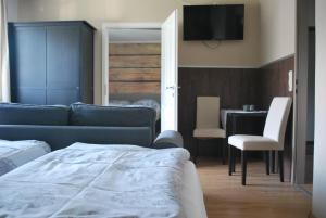 a bedroom with a couch and a table with a chair at Pension Leprich in Bad Goisern