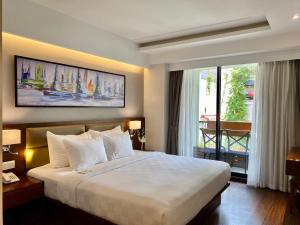 a hotel room with a large bed and a balcony at UpTown Hotel in Ho Chi Minh City
