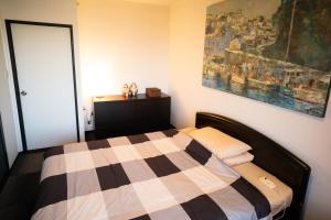 a bedroom with a bed and a painting on the wall at Jonni`s Place in Sakamoto