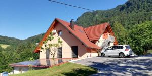 a white car parked in front of a house at Apartments Laznica in Cerkno