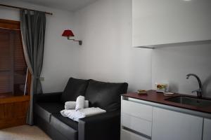 salon z kanapą i umywalką w obiekcie Comfortable apartment very close to the beach w Alcudii