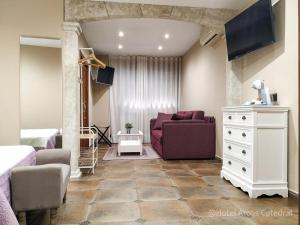 ein Wohnzimmer mit einem lila Sofa und einer Kommode in der Unterkunft Hotel Arcos Catedral in Ciudad-Rodrigo