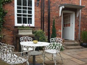 a table and two chairs and a table and a building at The Red House Guest House in Grantham