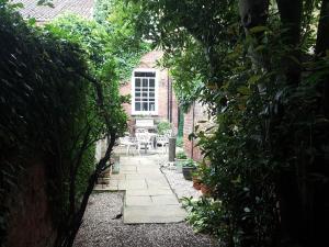 una entrada al jardín de una casa de ladrillo con un camino en The Red House en Grantham