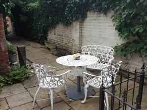 una mesa blanca y sillas en un patio en The Red House en Grantham
