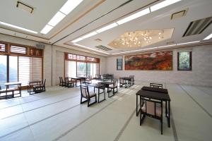 een eetkamer met tafels, stoelen en ramen bij Ryokan Nenrinbo in Kyoto