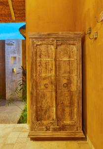 eine alte Holztür in der Ecke eines Gebäudes in der Unterkunft IVY VILLA in Mahabalipuram