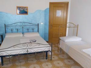 サルヴェにあるB&B Il Cedroのベッドルーム1室(ベッド2台付)、木製のドアが備わります。